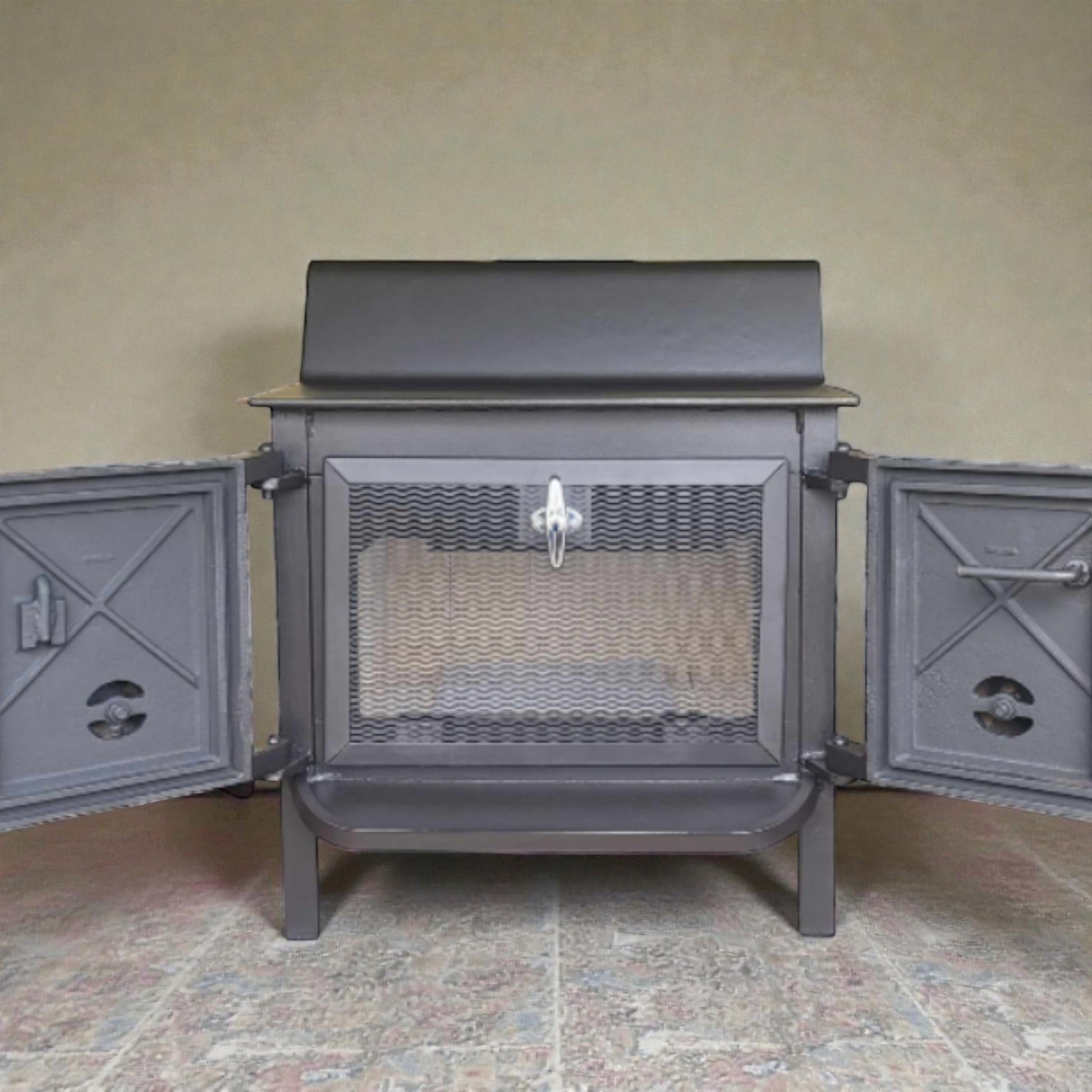 Gray metal stove with open doors on a tiled floor against a beige wall.