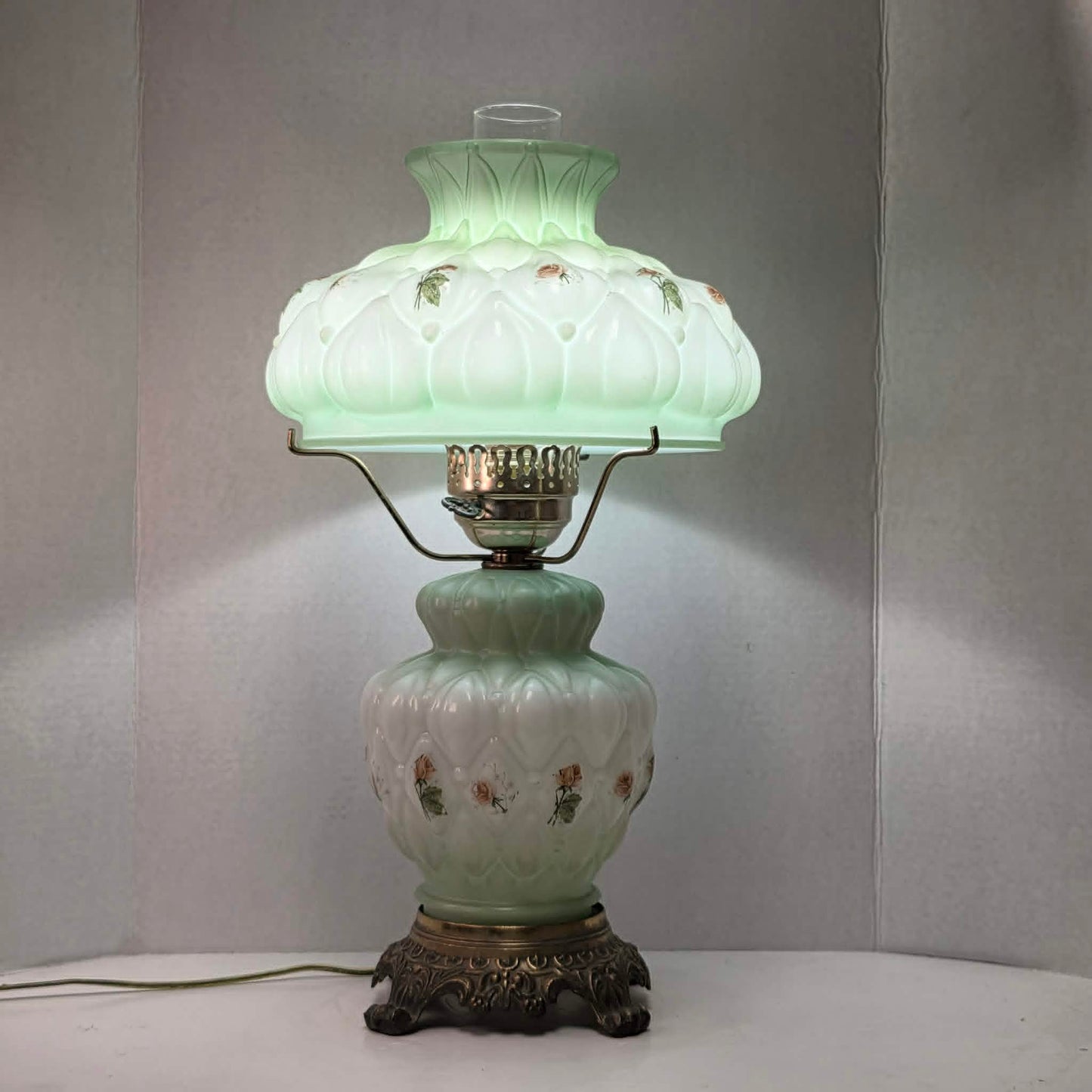 A beautiful vintage pastel green floral tri-light hurricane lamp offering classic elegance and a warm glow for any room.