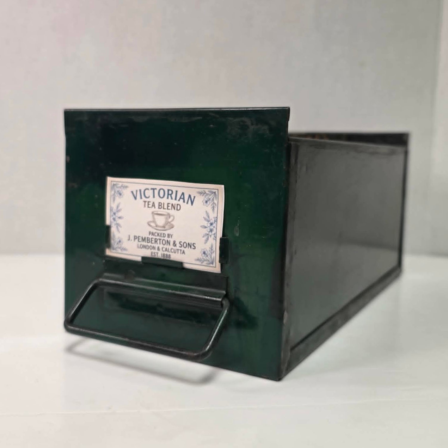 Antique industrial apothecary drawer with bail handle and label holder, vintage storage bin with aged patina.