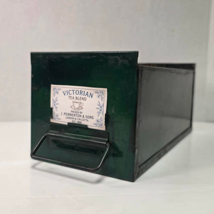 Antique industrial apothecary drawer with bail handle and label holder, vintage storage bin with aged patina.