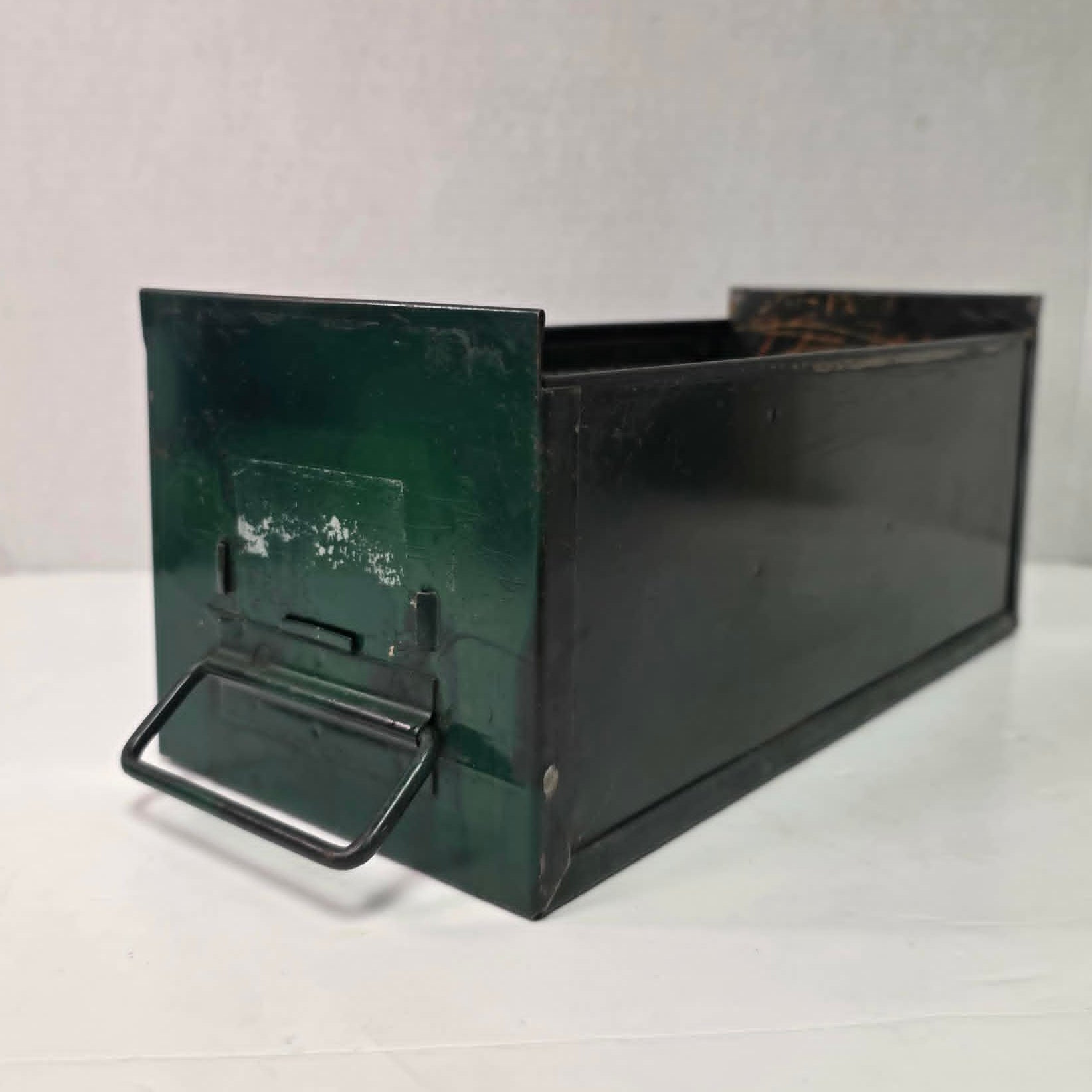 Antique industrial apothecary drawer with bail handle and label holder, vintage storage bin with aged patina.