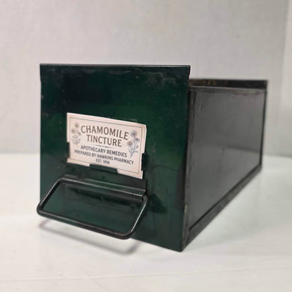 Antique industrial apothecary drawer with bail handle and label holder, vintage storage bin with aged patina.