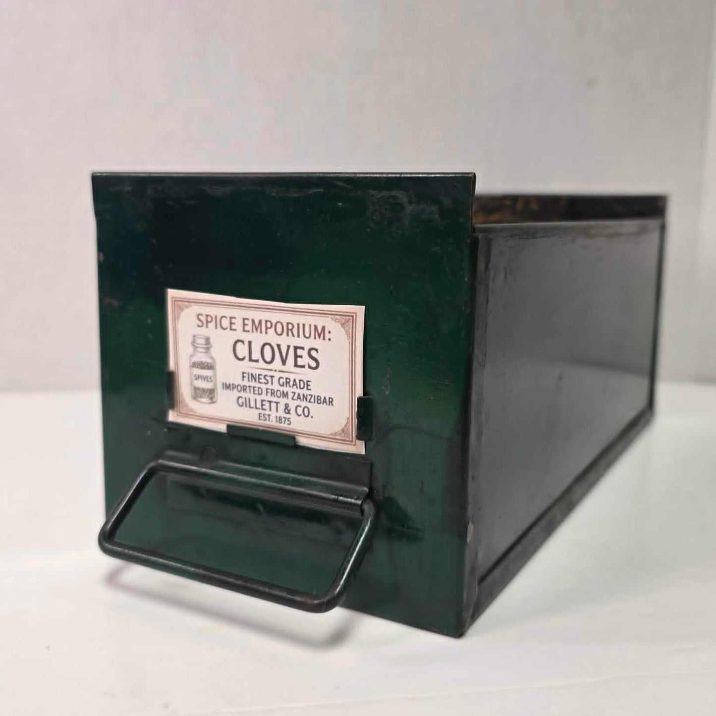 Antique industrial apothecary drawer with bail handle and label holder, vintage storage bin with aged patina.
