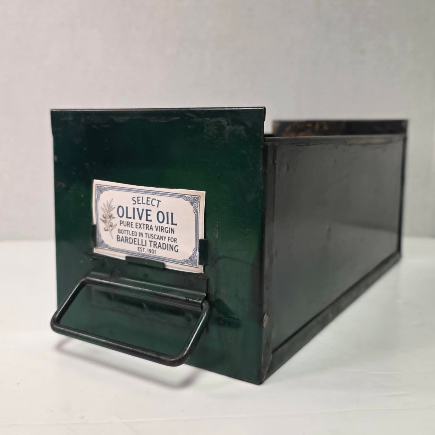 Antique industrial apothecary drawer with bail handle and label holder, vintage storage bin with aged patina.