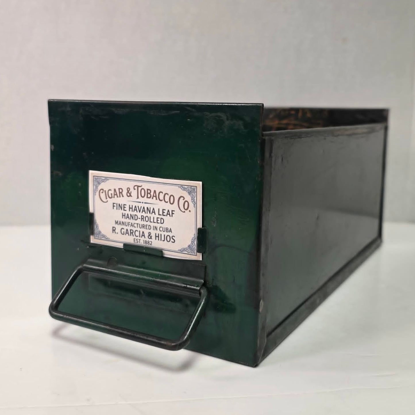 Antique industrial apothecary drawer with bail handle and label holder, vintage storage bin with aged patina.