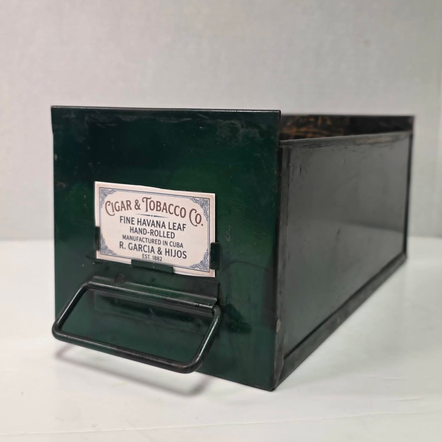 Antique industrial apothecary drawer with bail handle and label holder, vintage storage bin with aged patina.