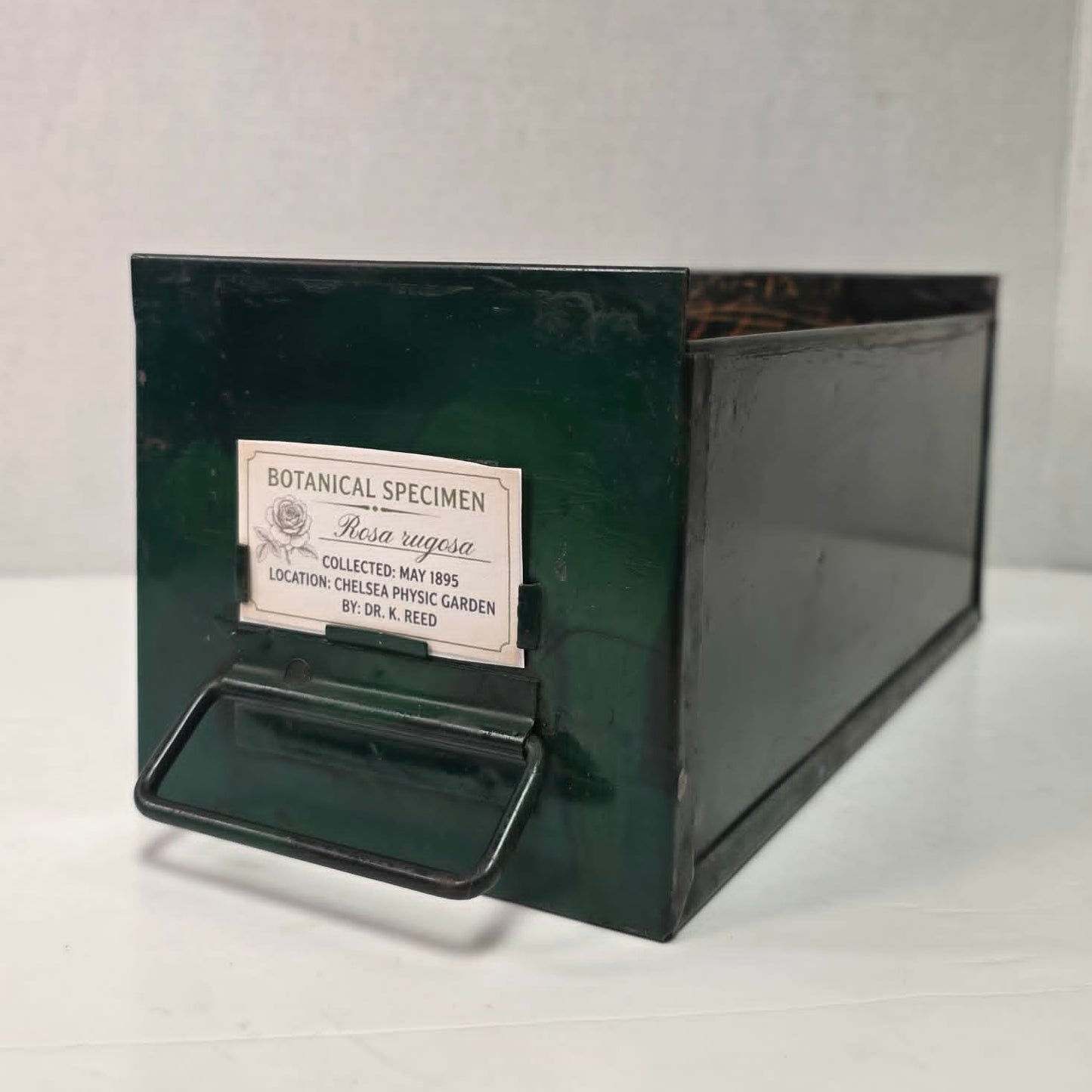 Antique industrial apothecary drawer with bail handle and label holder, vintage storage bin with aged patina.