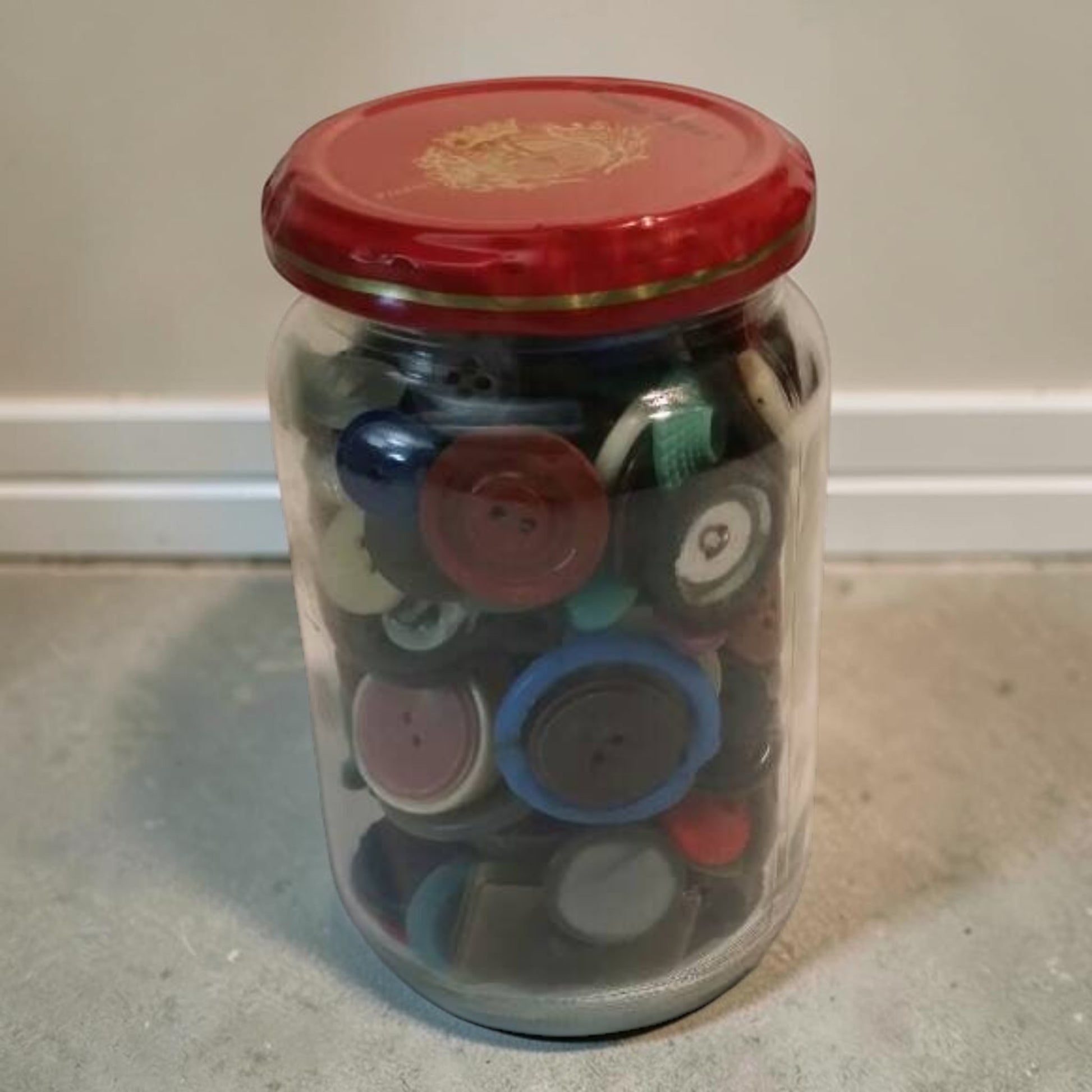 Jar filled with assorted antique vintage buttons for crafts and collectors.
