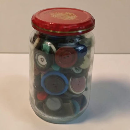 Jar filled with assorted antique vintage buttons for crafts and collectors.
