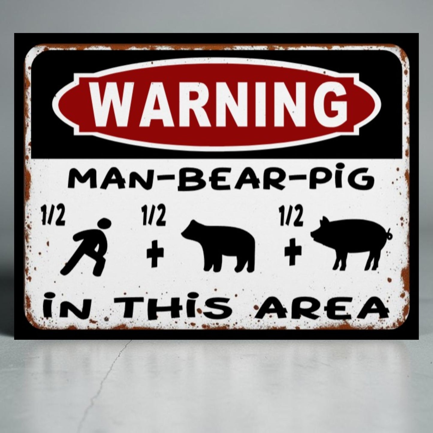 Metal sign with 'WARNING: MAN-BEAR-PIG IN THIS AREA' text and symbols on a gray background