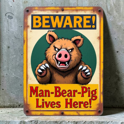 Metal sign with cartoon bear and text 'Beware! Man-Bear-Pig Lives Here!' on a concrete background