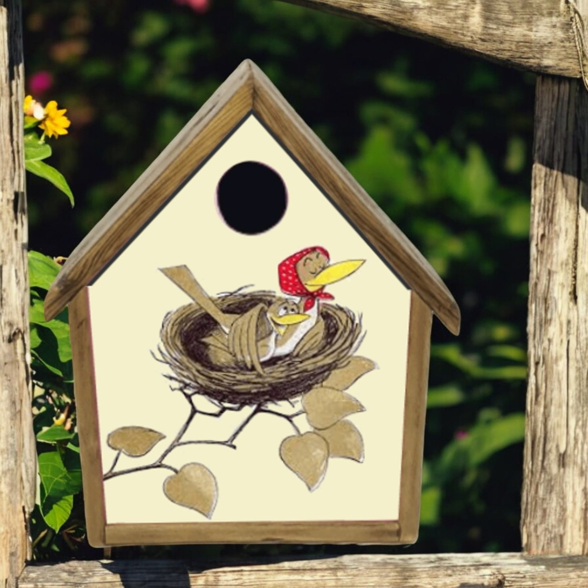 Wooden birdhouse with a painted design of birds in a nest on a natural background