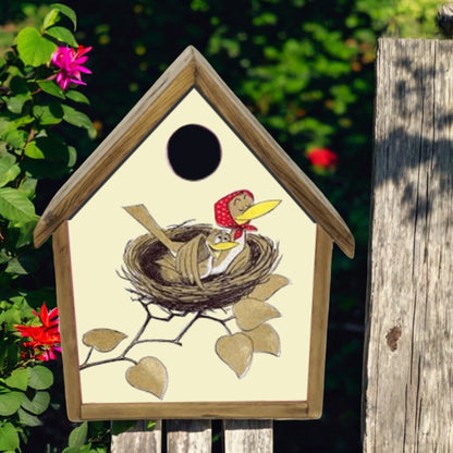Decorative birdhouse with a design of birds in a nest on a wooden post with flowers in the background.