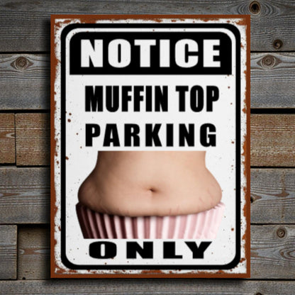 Metal sign with a graphic of a muffin top and text on a wooden background