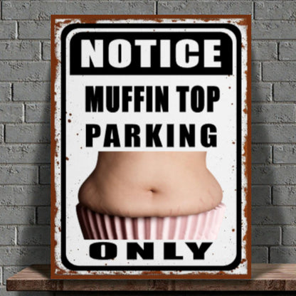 Metal sign with a graphic of a muffin top and text 'Notice Muffin Top Parking Only' on a brick wall background.