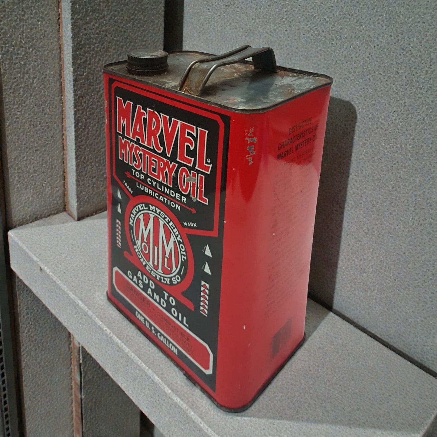 Red Marvel Mystery Oil can on a gray surface