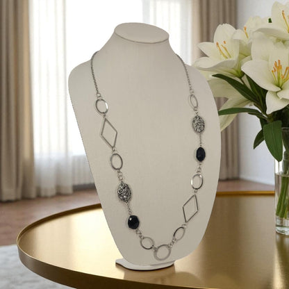 Necklace on a mannequin bust with flowers in the background
