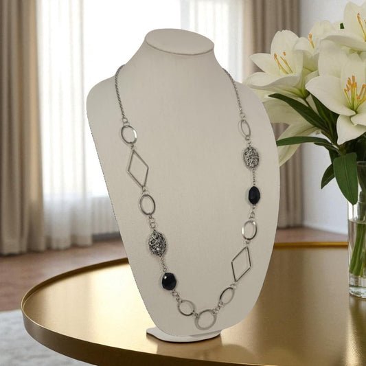 Necklace on a mannequin bust with flowers in the background