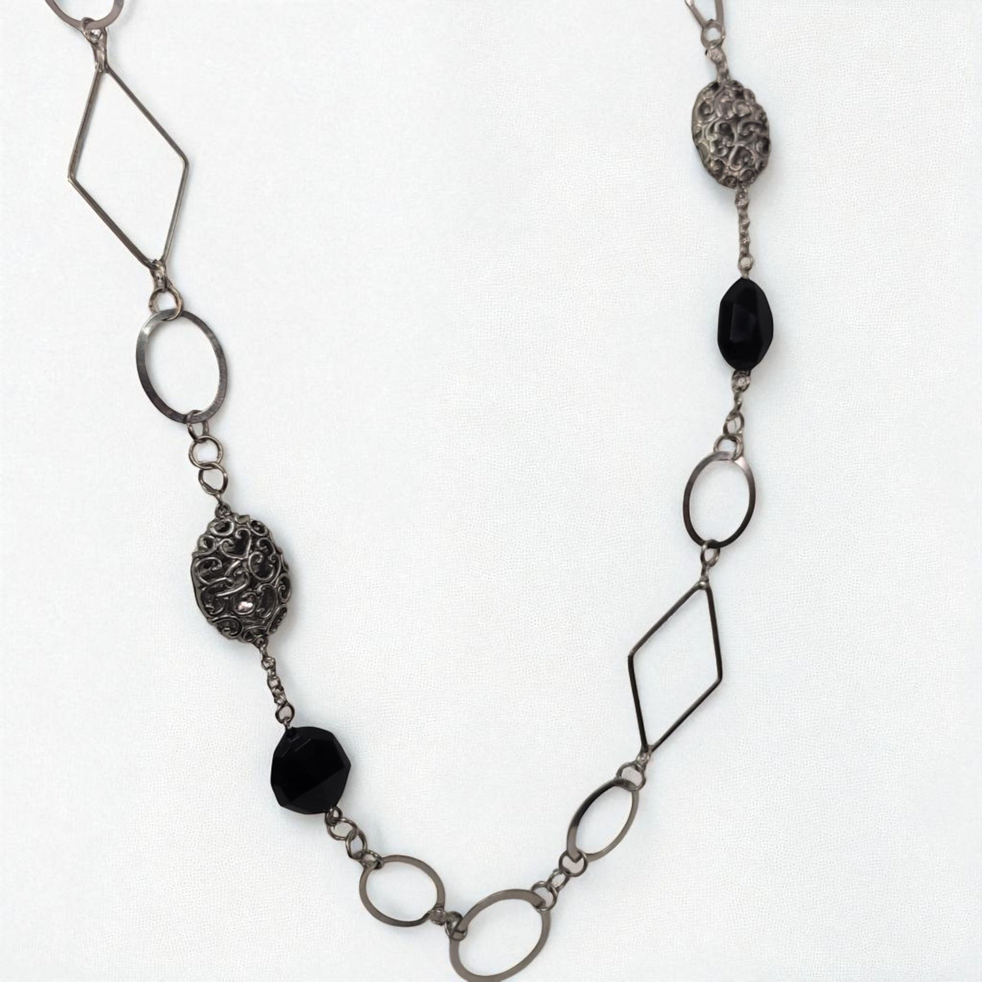 Necklace with geometric metal links and black beads on a white background