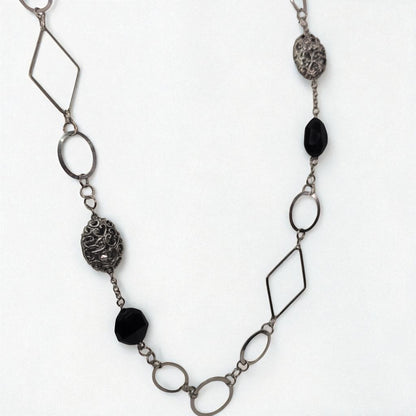 Necklace with geometric metal links and black beads on a white background