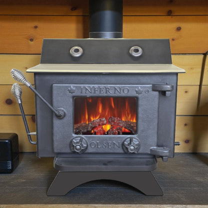 Wood stove with visible flames inside, branded 'Inferno Olsen', against a wooden wall.