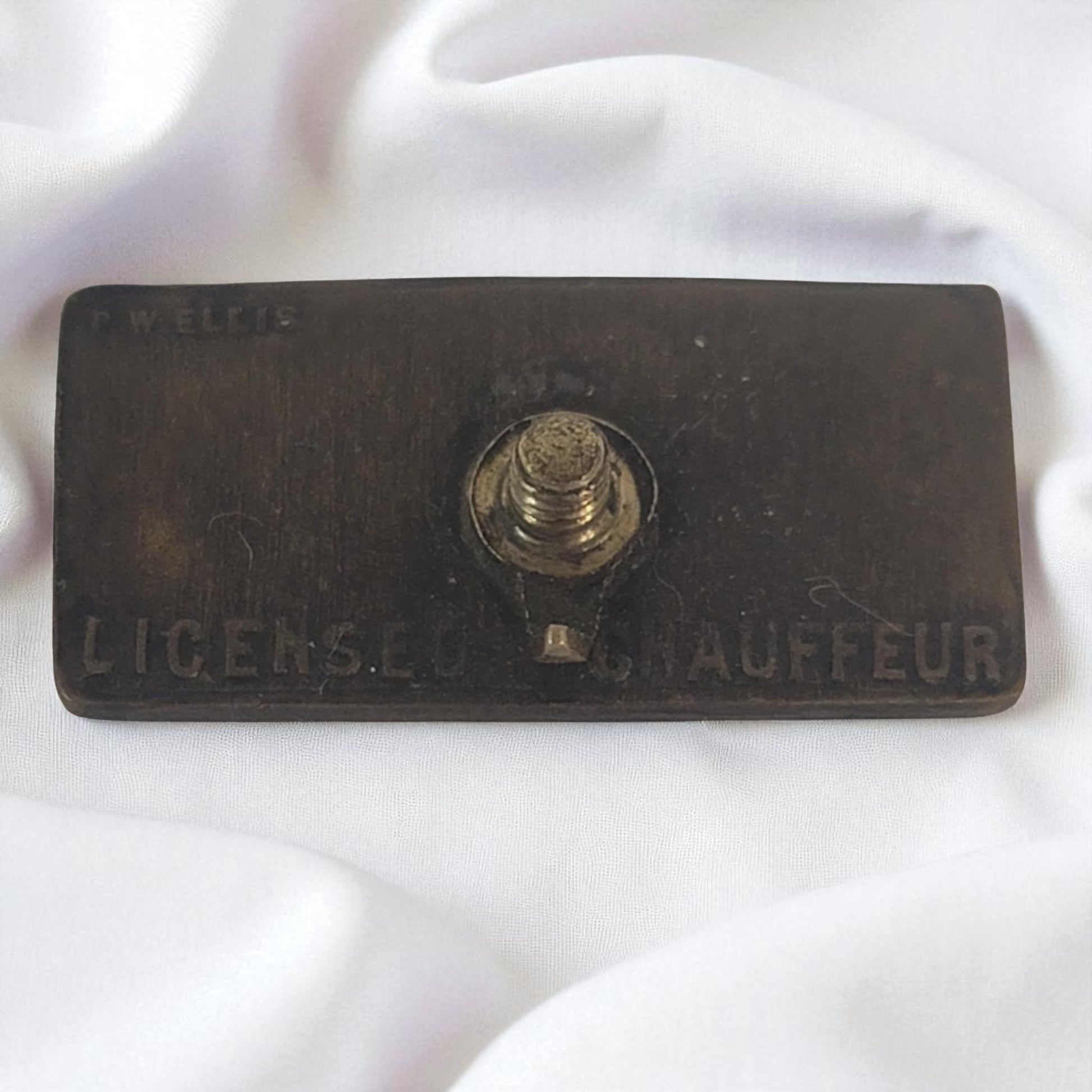 Vintage 'License Chauffeur' badge on a white background