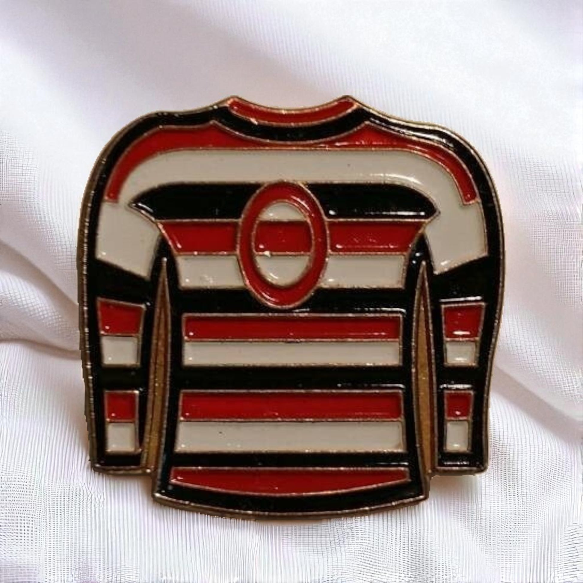 Pin with a design of a hockey jersey on a white background