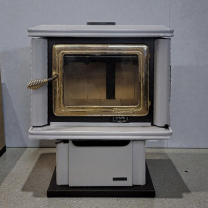 White wood stove with a gold interior on a gray floor and background