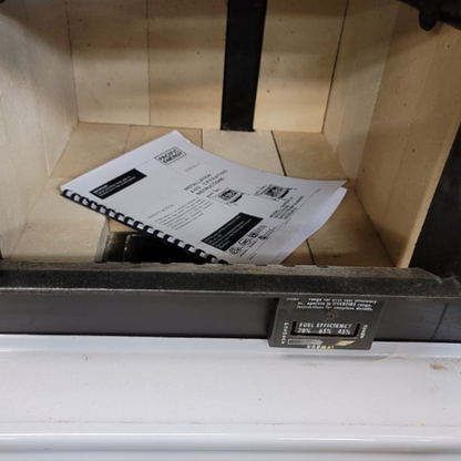 Document inside a cardboard box with a label on a tiled floor.