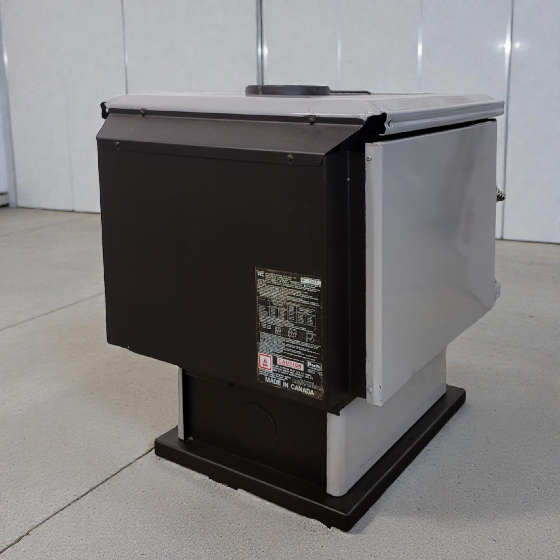 Black and white machine on a gray floor with a white wall background