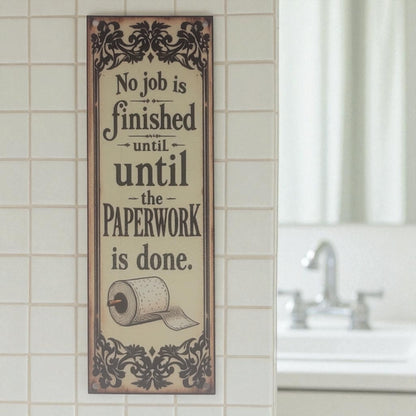 Decorative sign with humorous quote on a tiled bathroom wall.
