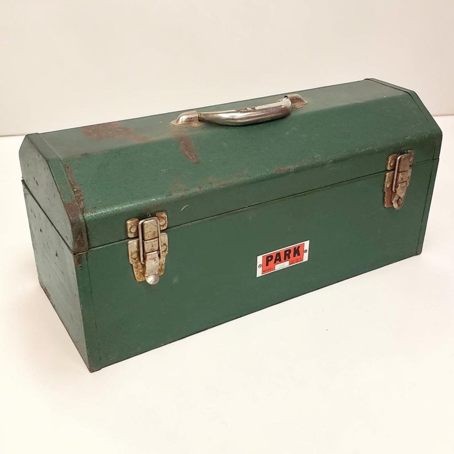 Green metal toolbox with 'PARK' label on a white background