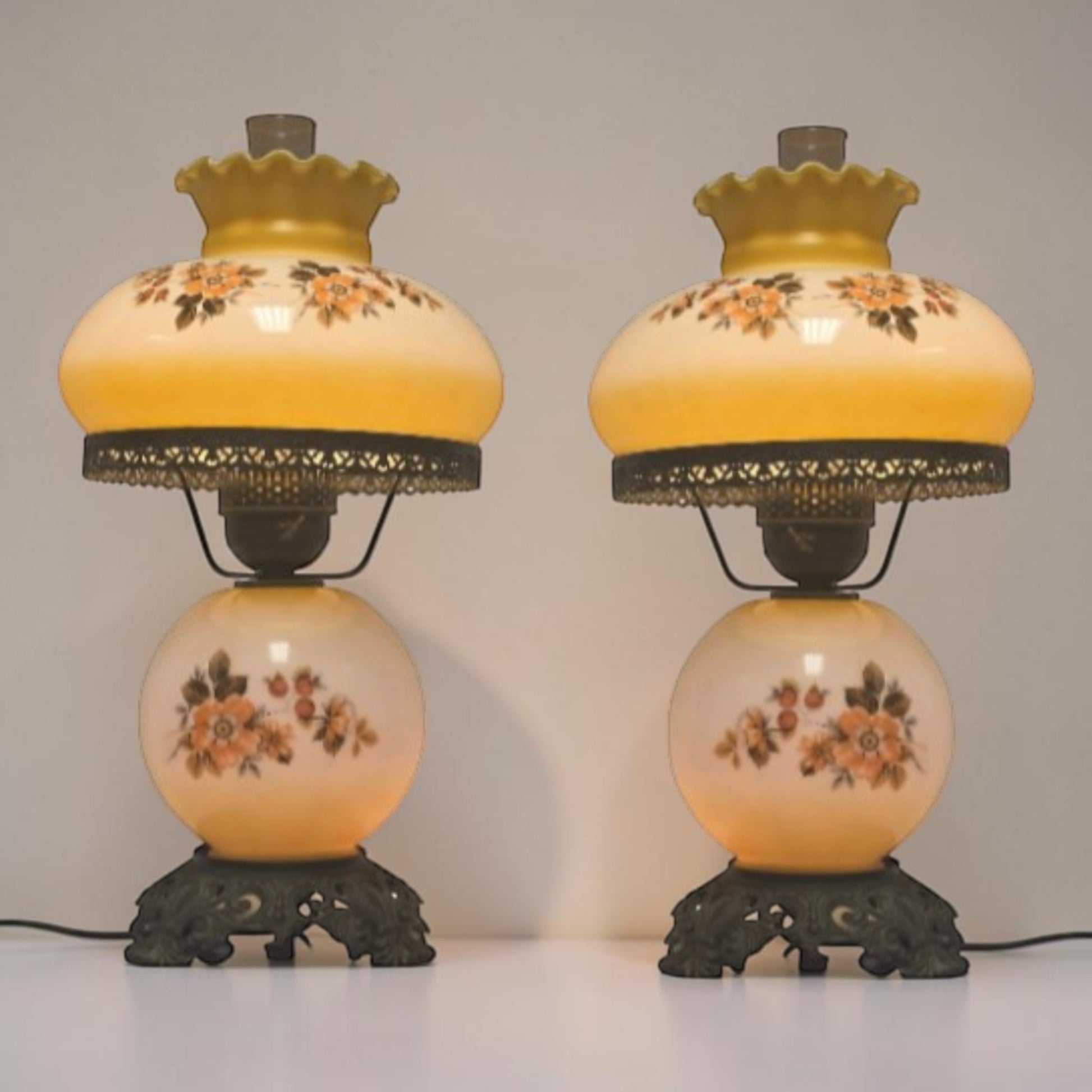 Pastel yellow Gone with the Wind hurricane lamp with peach floral decoration and tri-light lighting.