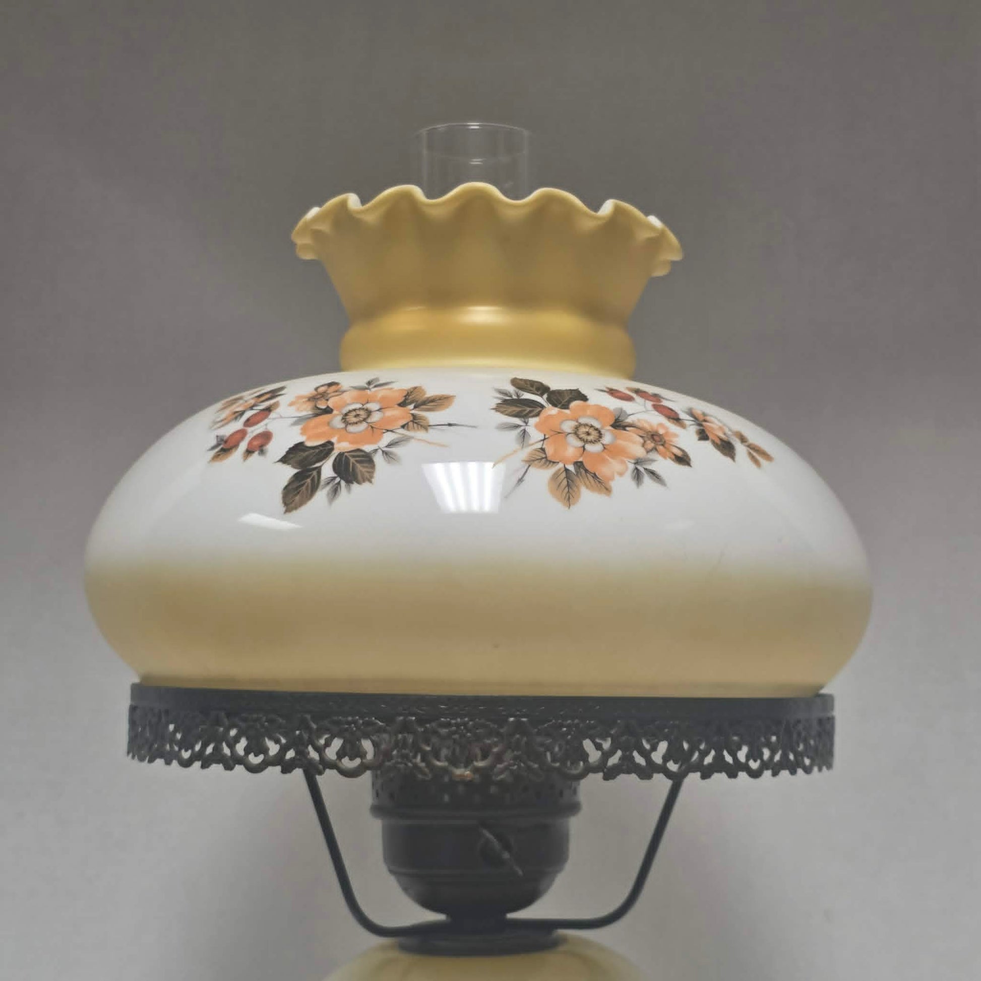 Pastel yellow Gone with the Wind hurricane lamp with peach floral decoration and tri-light lighting.