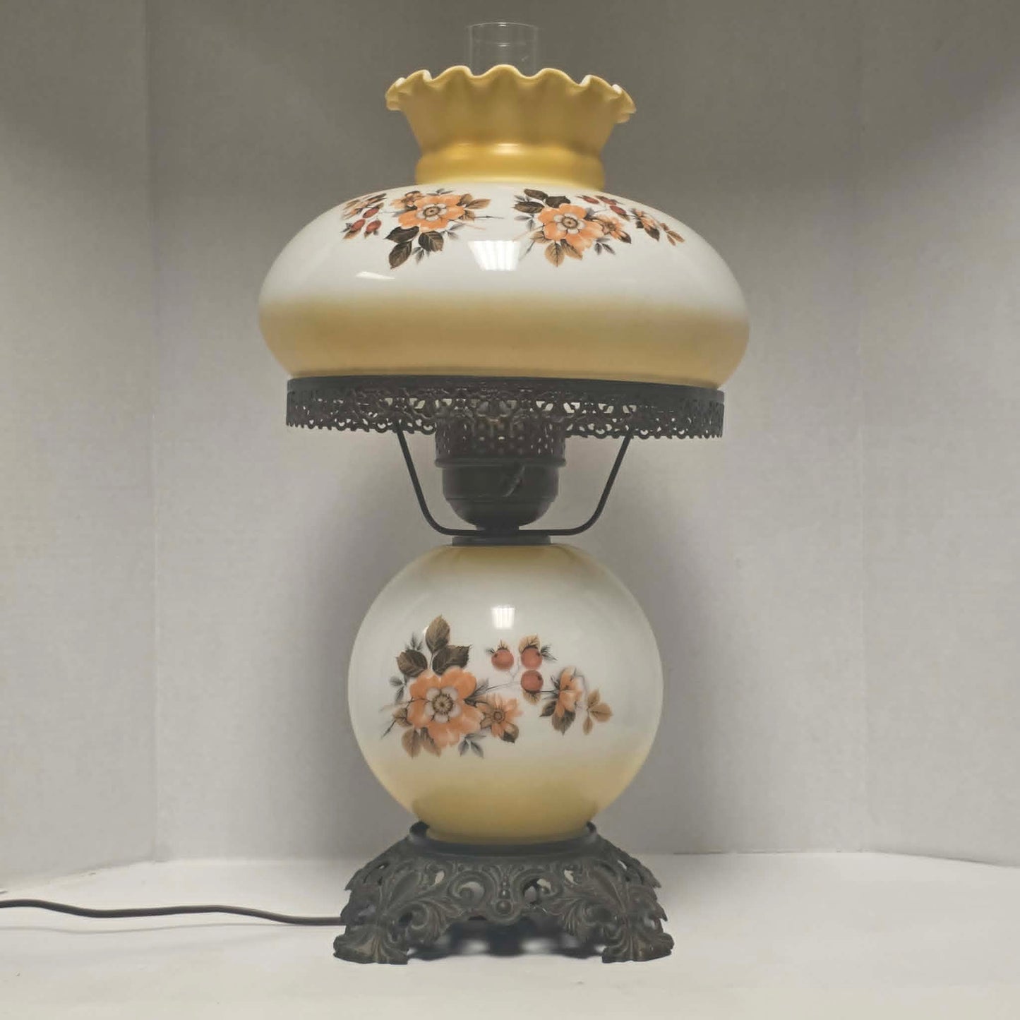 Pastel yellow Gone with the Wind hurricane lamp with peach floral decoration and tri-light lighting.