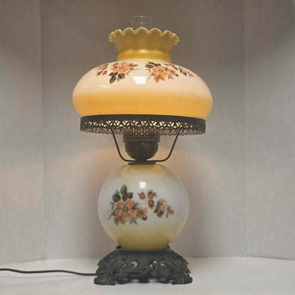 Pastel yellow Gone with the Wind hurricane lamp with peach floral decoration and tri-light lighting.