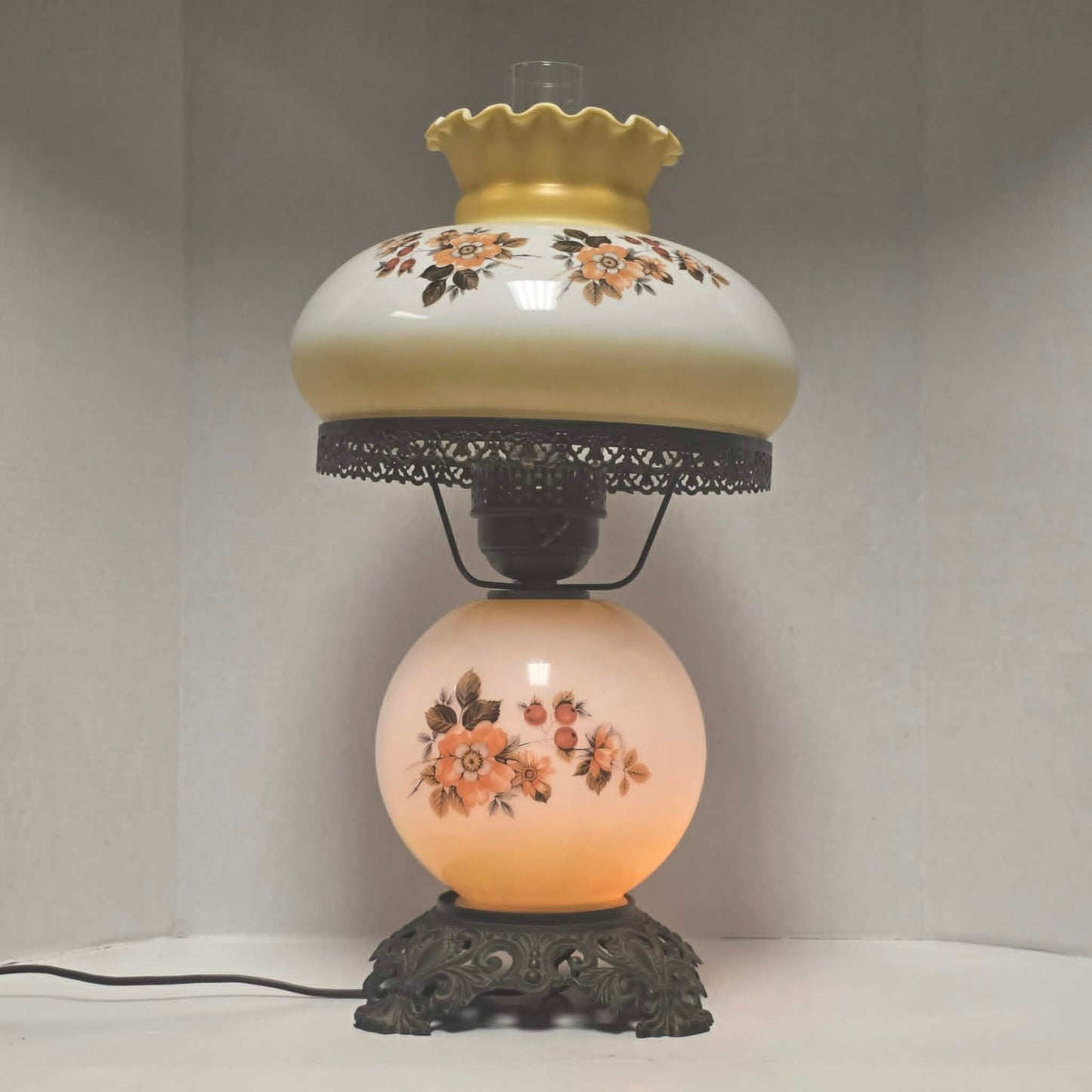 Pastel yellow Gone with the Wind hurricane lamp with peach floral decoration and tri-light lighting.