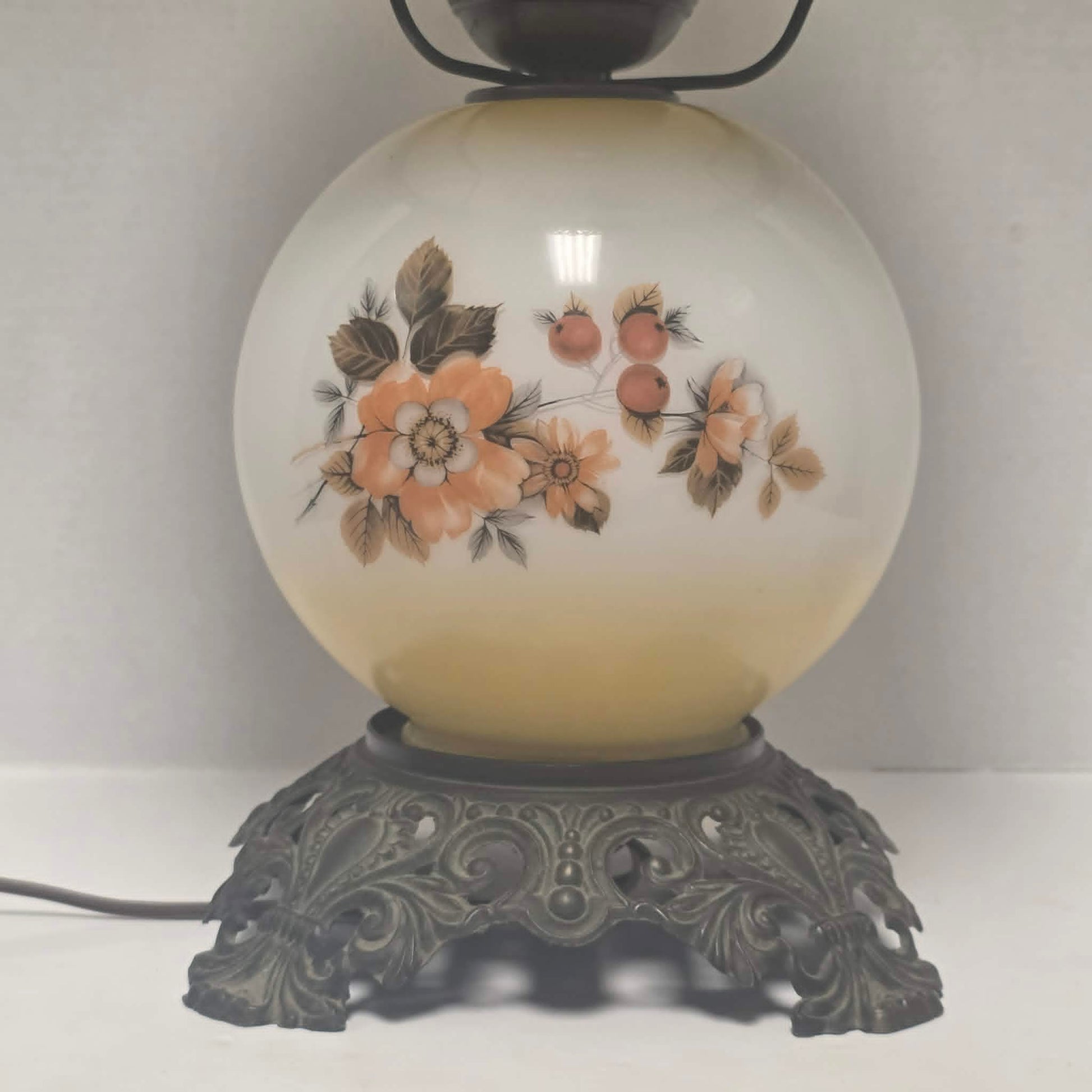 Pastel yellow Gone with the Wind hurricane lamp with peach floral decoration and tri-light lighting.