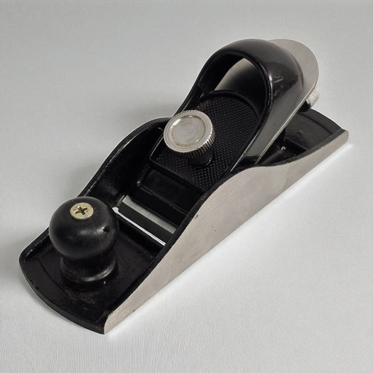 Black and silver hand plane on a white background