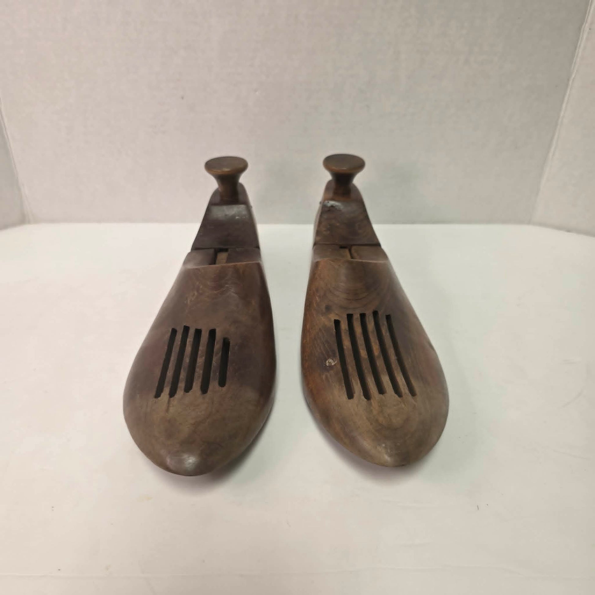 Pair of antique primitive wooden shoe stretchers with pegged construction and aged patina, early cobbler tools with articulated joint.