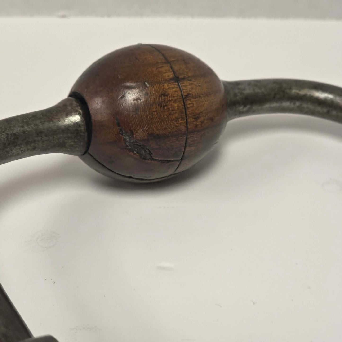 An exquisitely crafted antique walnut-handled bit brace that showcases the beauty and precision of early woodworking tools.
