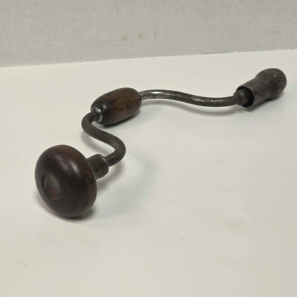 Antique primitive carpenter's bit brace with wood and brass handle.

