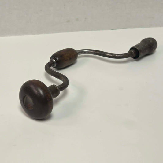 Antique primitive carpenter's bit brace with wood and brass handle.
