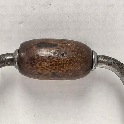 Antique primitive carpenter's bit brace with wood and brass handle.
