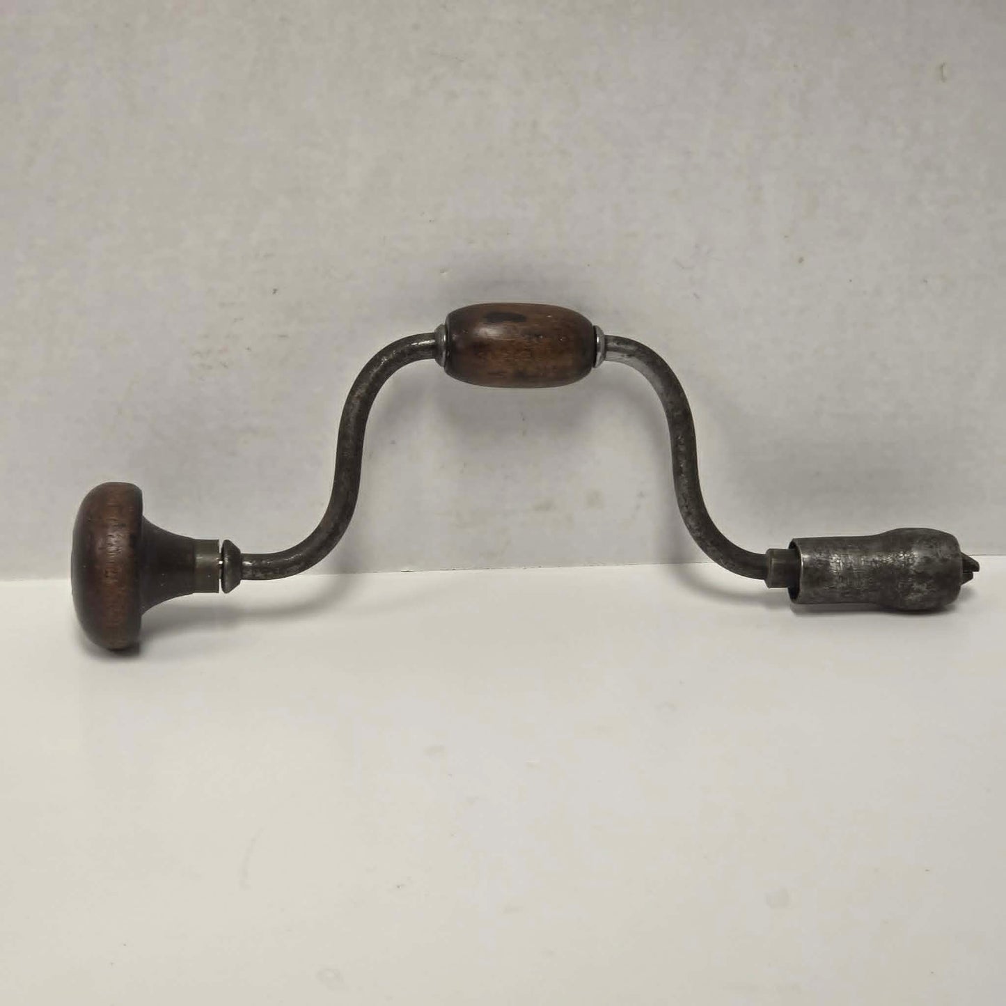 Antique primitive carpenter's bit brace with wood and brass handle.

