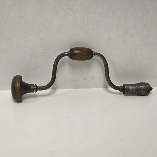 Antique primitive carpenter's bit brace with wood and brass handle.

