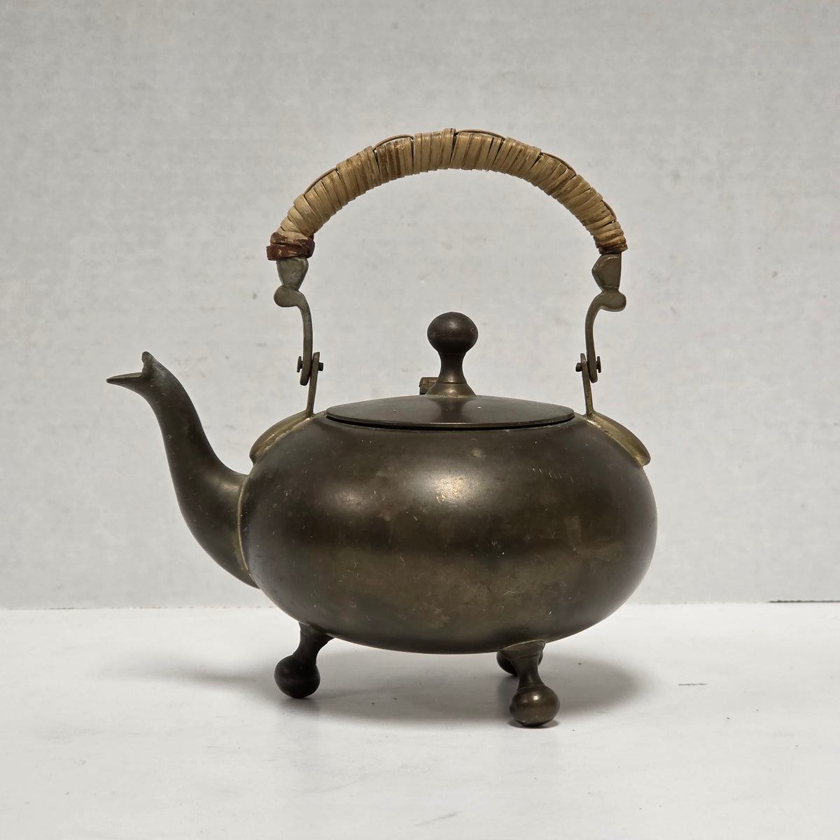 Dainty primitive brass teapot with rattan handle
