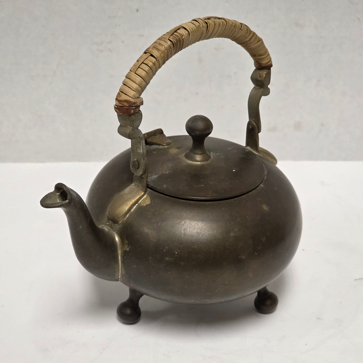 Dainty primitive brass teapot with rattan handle
