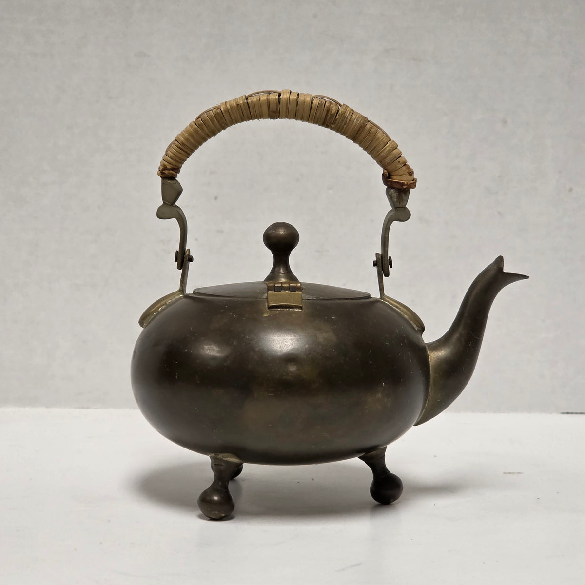 Dainty primitive brass teapot with rattan handle
