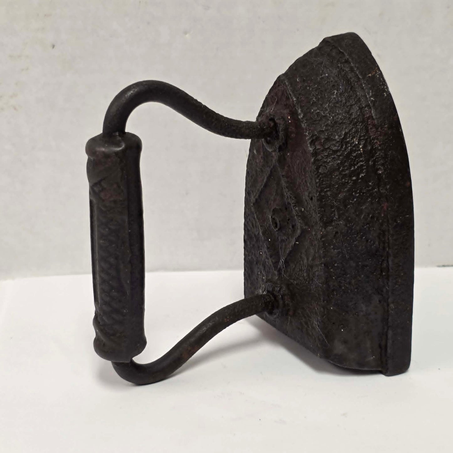 Antique Taylor Forbes No. 6 cast iron sad iron with diamond marking and patterned handle.
